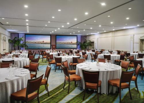 a banquet room with tables and chairs and large screens at Hotel del Coronado, Curio Collection by Hilton in San Diego