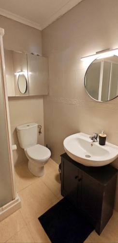 a bathroom with a sink and a toilet and a mirror at Casa Mediterránea Kai in Gran Alacant