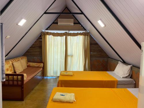 ein Dachzimmer mit zwei Betten und einer Couch in der Unterkunft Pousada MAKS in Ribeirão Preto