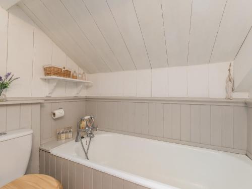 a bathroom with a bath tub and a toilet at Englewood Cottage in Hexham