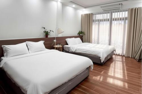 a hotel room with two beds and a window at Mom's home in Ninh Binh