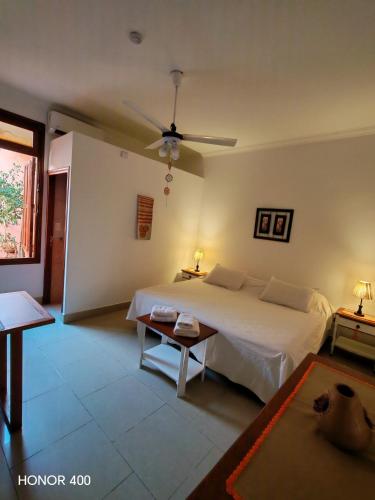 a bedroom with a large bed and a table at Hostal Virgen del Rosario Cafayate in Cafayate