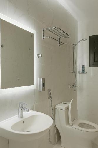a bathroom with a sink and a toilet and a mirror at Sunshine Flat in Al Khobar