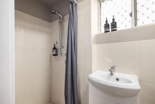 a white bathroom with a sink and a shower at Ocean Shores 1 in South West Rocks