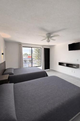 a bedroom with a bed and a ceiling fan at Hotel Nuevo Vallarta in Guadalajara