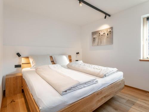 a bed in a room with white walls at Haus Tauernblick Top 4 in Jochberg