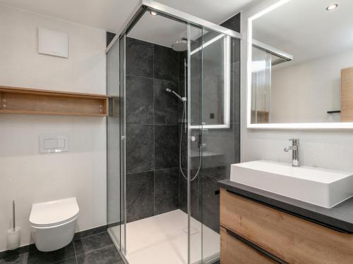 a bathroom with a shower and a toilet and a sink at Haus Tauernblick Top 4 in Jochberg