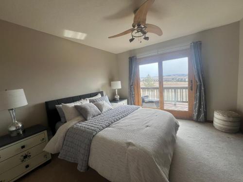a bedroom with a bed with a ceiling fan and a window at Bayou Hills BnB in Parker