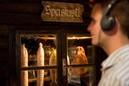 a man wearing headphones looking out of a window at Pension Jageredt in Nussbach