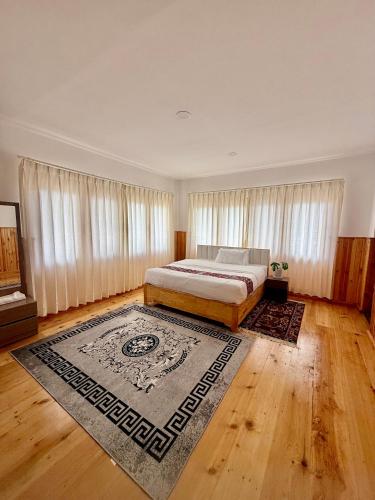 a bedroom with a bed and a rug at Sompal Service Apartment in Paro