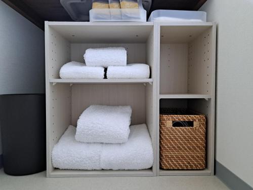 a closet with white towels and a basket at Iso Ocean Breeze Villa in Kyotango