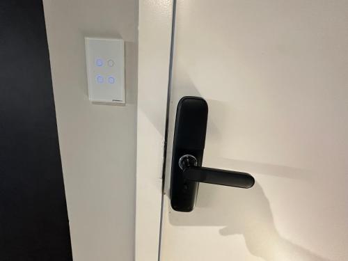 a black door handle on a white door at Studios Botânico in Curitiba