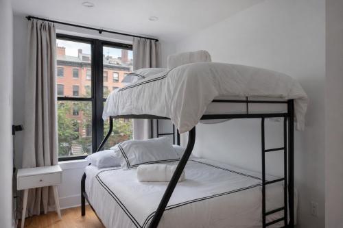 a bunk bed in a room with a window at Three Bedroom Brooklynite Condo-Hotel Suite! in Brooklyn