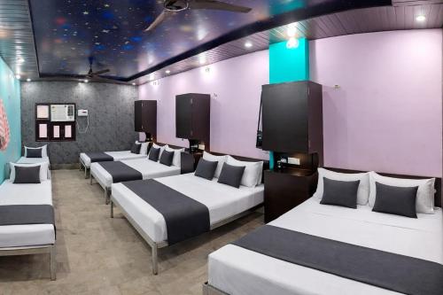 a row of beds in a room with purple walls at Hotel In Kashi in Varanasi