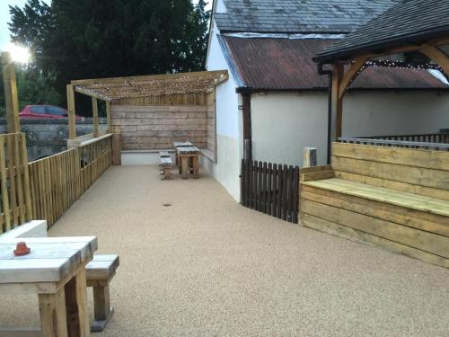 a patio with a fence and a table and benches at The Wheatsheaf in Salisbury