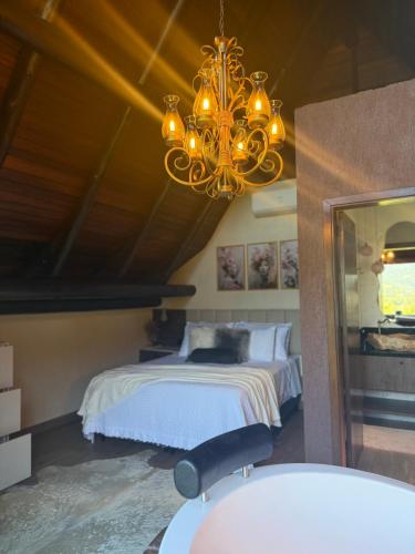 a bedroom with a bed and a chandelier at Cabana Valle Pietra in Nova Petrópolis