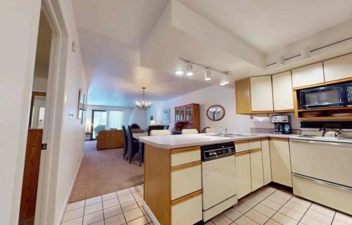 Enzian - CoralTree Residence Collection في فيل: مطبخ بخزائن بيضاء وغرفة طعام
