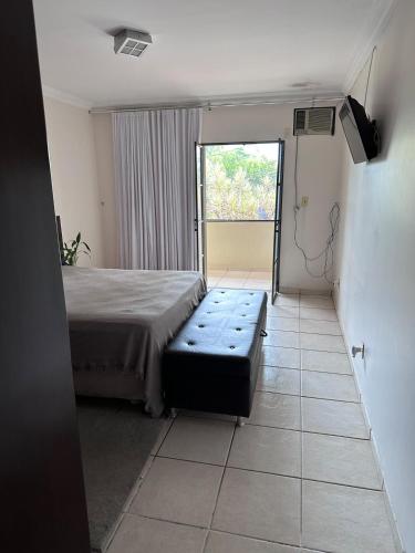 a bedroom with a bed and a large window at Moto GP sobrado in Goiânia