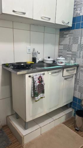 a white kitchen with a stove and a sink at Na Ladeira Studio 06 in Rio de Janeiro