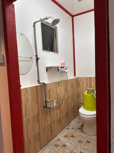 a bathroom with a toilet and a tv on the wall at BIHING ANGAN water chalets in Semporna