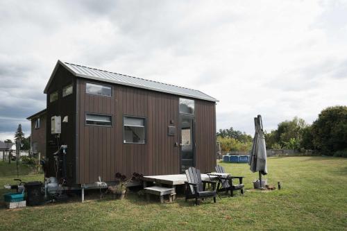 a tiny house with a picnic table and an umbrella at Sweet Hart 1 by Tiny Away in Tamahere