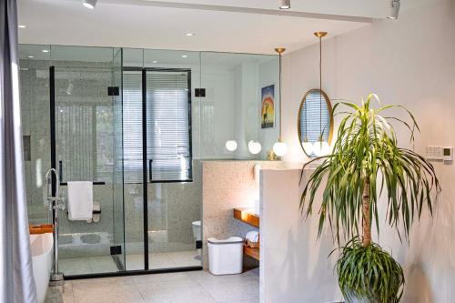 a bathroom with a shower and a potted plant at Sanfuyizhai Homestay in Taizhou