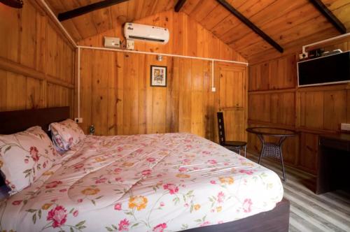 a bedroom with a bed in a room with wooden walls at Club Palolem Resort in Palolem