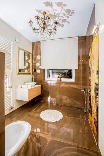 a bathroom with a sink and a tub and a mirror at Angel's Nest Apartment in Komenda