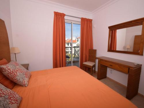 a bedroom with a bed and a desk and a window at Sunny Balcony Apartment and Pool in Vilamoura