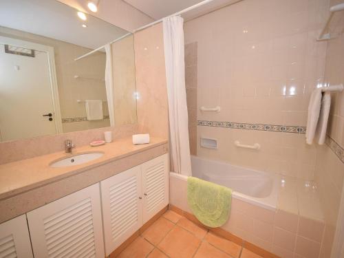 a bathroom with a sink and a bath tub at Sunny Balcony Apartment and Pool in Vilamoura