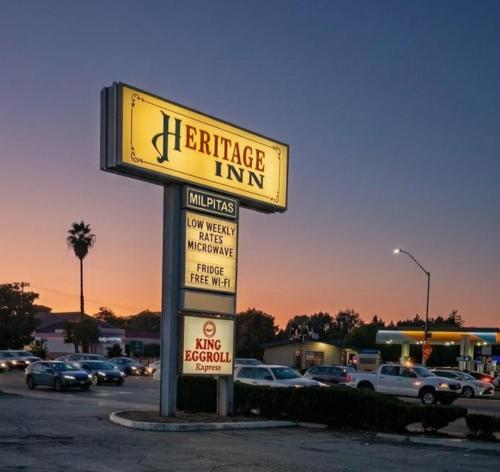 a sign for a furniture inn in a parking lot at Heritage Inn - Milpitas in Milpitas