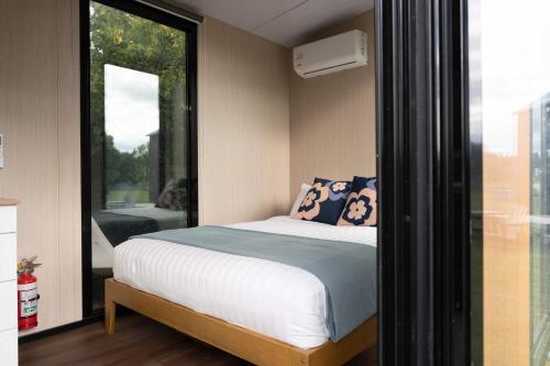 a small bedroom with a bed and a window at Sweet Hart 2 by Tiny Away in Tamahere