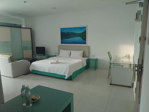 a bedroom with a bed and a couch and a table at Santorini Hotel in Miri
