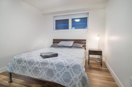 a white bedroom with a bed and a window at Appartement 2 chambres, centre ville, séjour longue durée in Quebec City