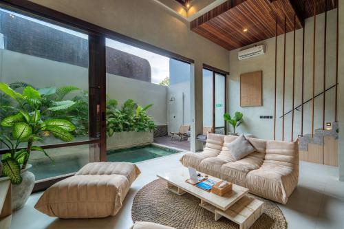 a living room with a couch and a table at Unwind Villa by Betterplace in Canggu