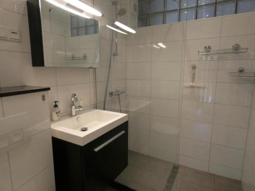 a white bathroom with a sink and a shower at Ferienhaus in am Teutoburger Wald in Husen