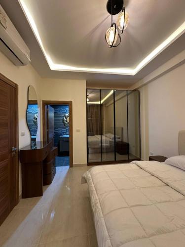 a bedroom with a bed and a sink and a mirror at Sharm Hills Azure Suite Topview in Sharm El Sheikh