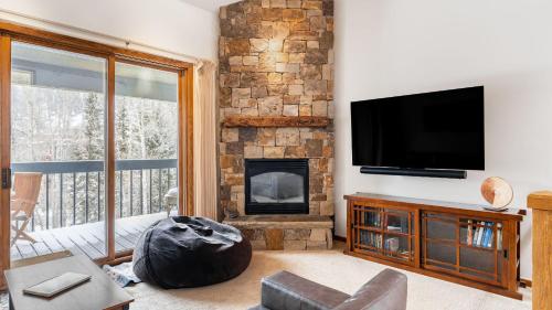 a living room with a fireplace and a flat screen tv at Riverside Condos C202 by AvantStay Condo Close To Downtown Town Park Ski Lift 8 in Telluride