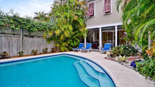a swimming pool in front of a house at Amelia Home by AvantStay In Historic Old Town w Pool in Key West