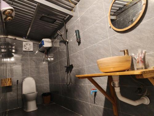 a bathroom with a toilet and a mirror at LÝ GIA HOMESTAY in Ha Giang