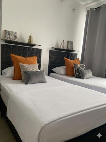 two beds sitting next to each other in a room at Tu Espacio en Ibague in Ibagué