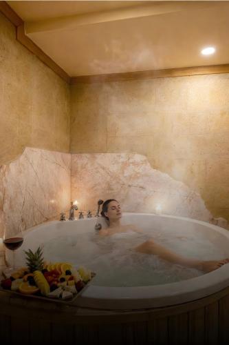 a woman is sitting in a bath tub at Cratus Stone Palace in Göreme