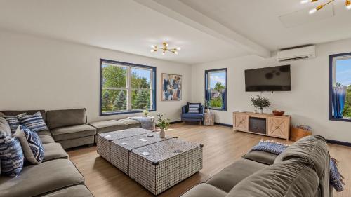 a living room with a couch and a tv at For Lake Sake by AvantStay Lakefront Hot Tub View in Long Pond