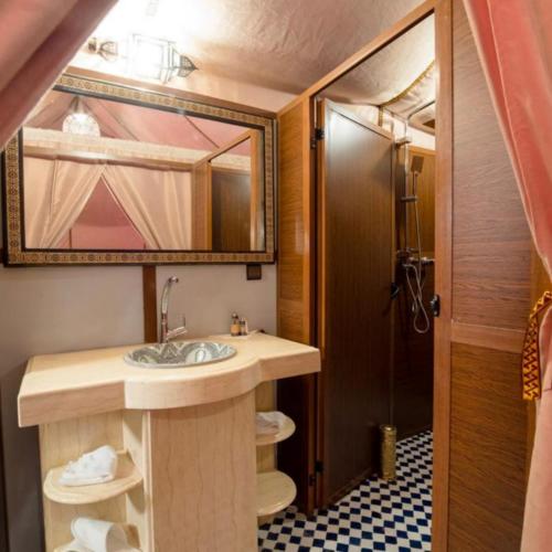a bathroom with a sink and a mirror at Fantastic Luxury Dunes Camp in Merzouga