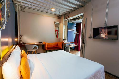 a bedroom with a bed and a desk in a room at MeStyle Garage Hotel in Bangkok