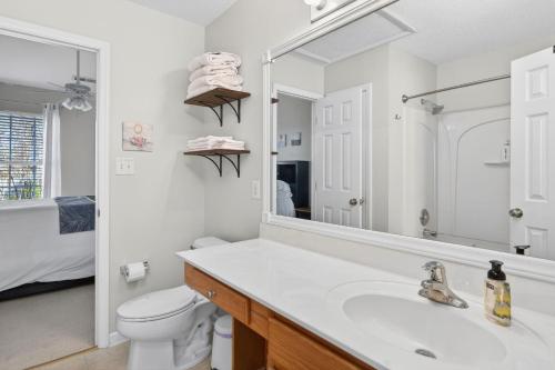 a bathroom with a sink and a toilet and a mirror at Executive & Luxury 2-bedroom Townhouse with Pool in Greensboro