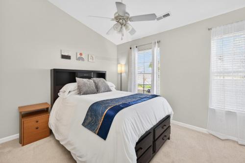 a white bedroom with a bed and a ceiling fan at Executive & Luxury 2-bedroom Townhouse with Pool in Greensboro