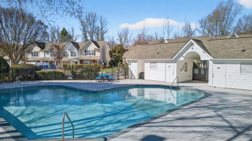 a swimming pool in front of a house at Executive & Luxury 2-bedroom Townhouse with Pool in Greensboro