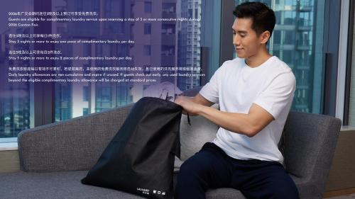a man sitting on a couch holding a black bag at Hyatt Regency Guangzhou Zengcheng in Guangzhou