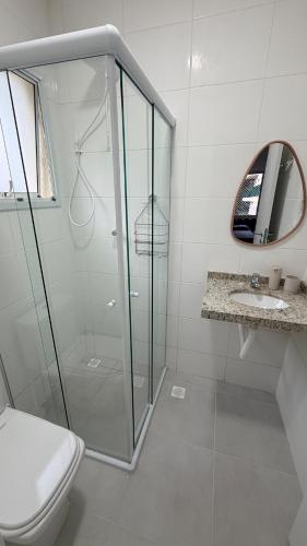 a bathroom with a shower and a toilet and a sink at Refúgio com estilo 2 Quartos 6 Pessoas in Bertioga